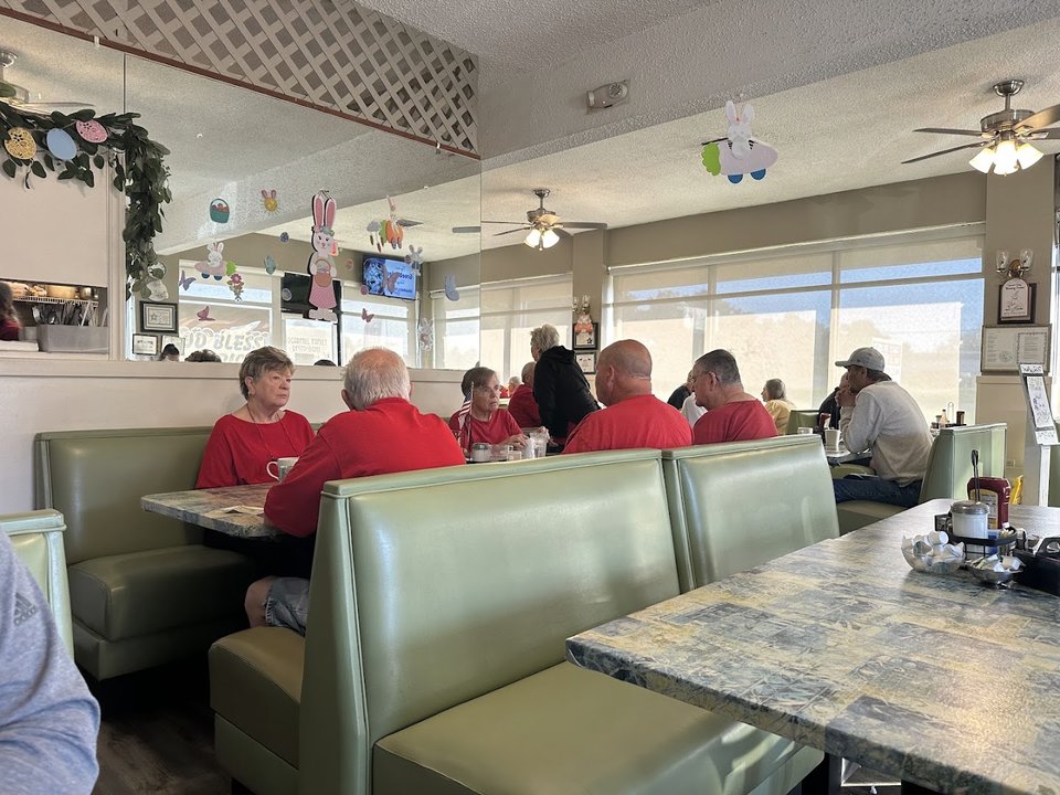 Bright family restaurant dining room with booth seating.